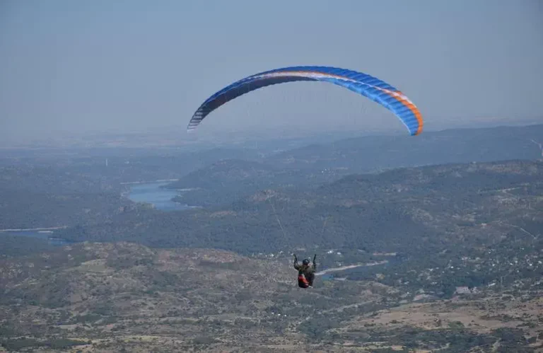 a person in a parachute over a valley