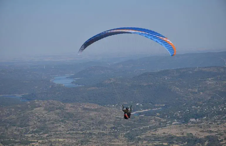 a person in a parachute over a valley