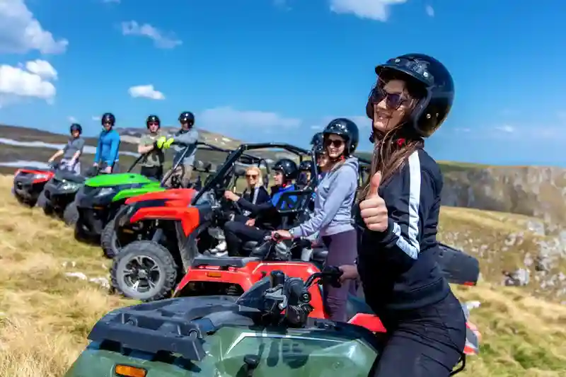 Group of friends riding colourful Quad bikes across off-road trails and rugged terrain.